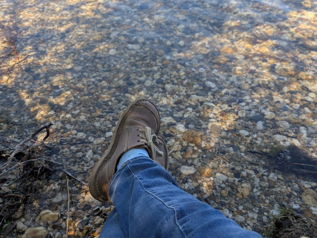Gedanken-abschweifen-am Wasser Füße, die entspannt über einer Wasserfläche schweben